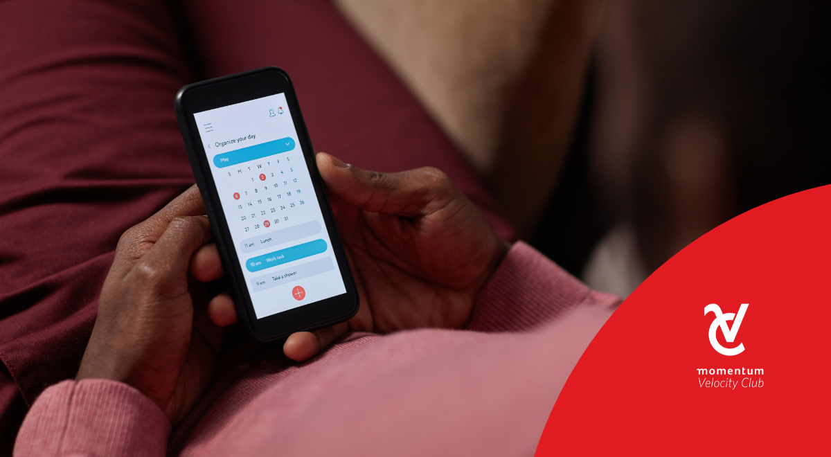 A young man setting aside time on his cell phone calendar for a money review.