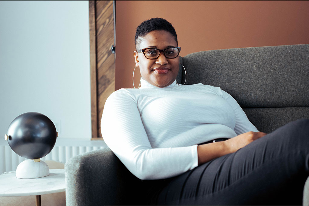 Confident, young African woman sitting confidently on a couch.