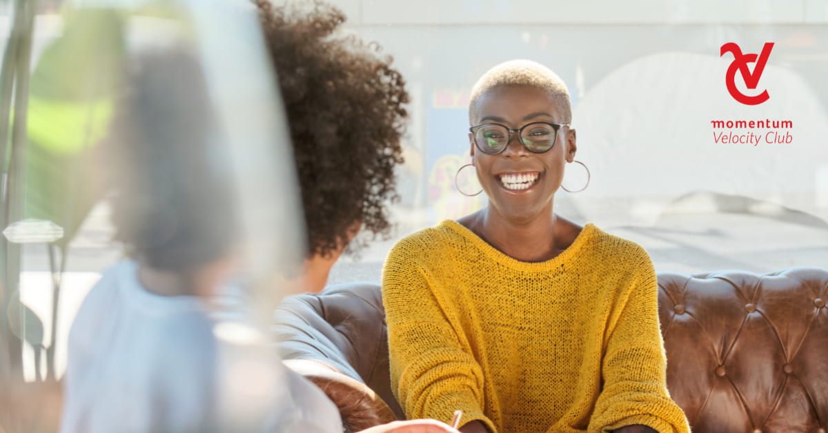 Two women speaking as one explains different financial terms to the other.