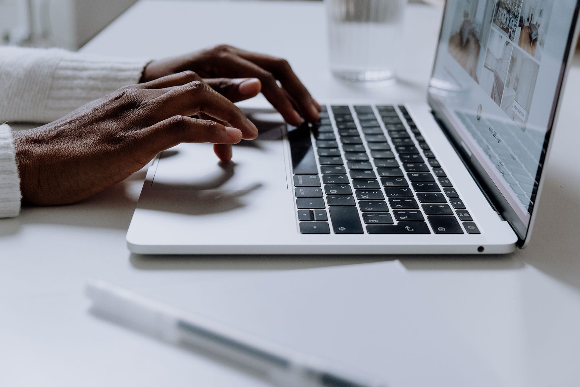 Mans hands typing on a laptop keyboard.